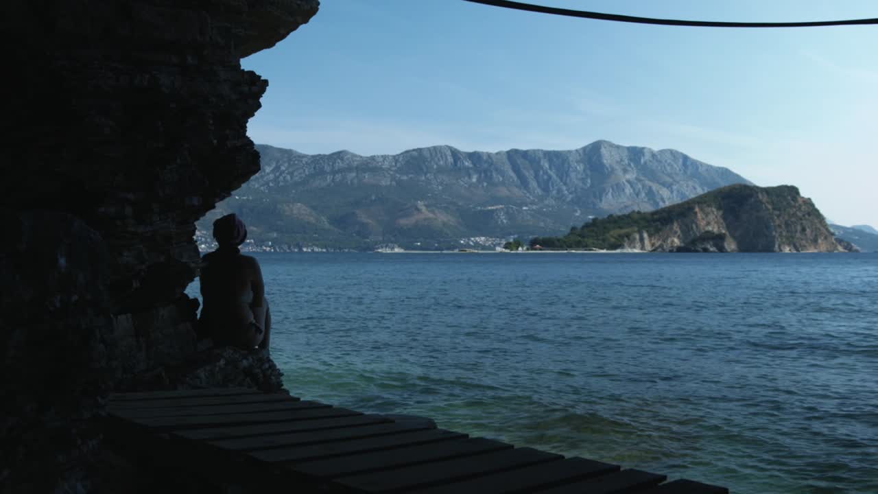 mujer observando la vista del mar desde una cueva