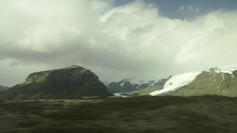 view from a car window driving in iceland, mountains, glacier, clouds