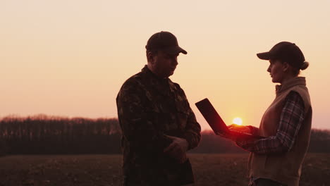 farmers man and woman work in the field use a laptop