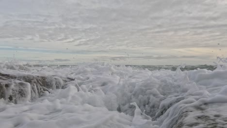 ocean waves splashing against rocks at the beach