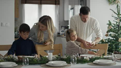 Matrimonio-Caucásico-Con-Niños-Preparando-La-Mesa-Para-La-Víspera-De-Navidad.