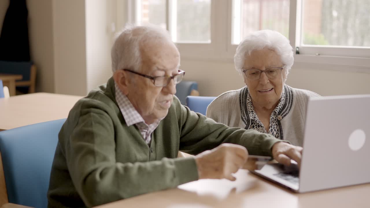 Senior people shopping online using credit card and laptop