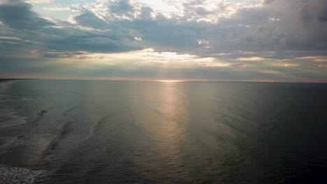 Amanecer-Temprano-En-La-Mañana-Drone-Hacia-Atrás-Sobrevuelo-Lejos-De-La-Playa-En-Shell-Island-Frente-A-La-Isla-Figura-Ocho-En-Wilmington,-Carolina-Del-Norte