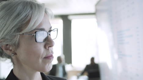 Cropped closeup portrait of businesswoman in glasses looking at the screen