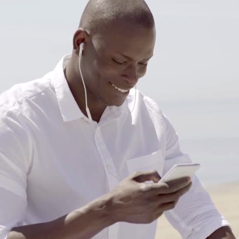 Man-listening-to-music-on-cell-teléfono-while-seated