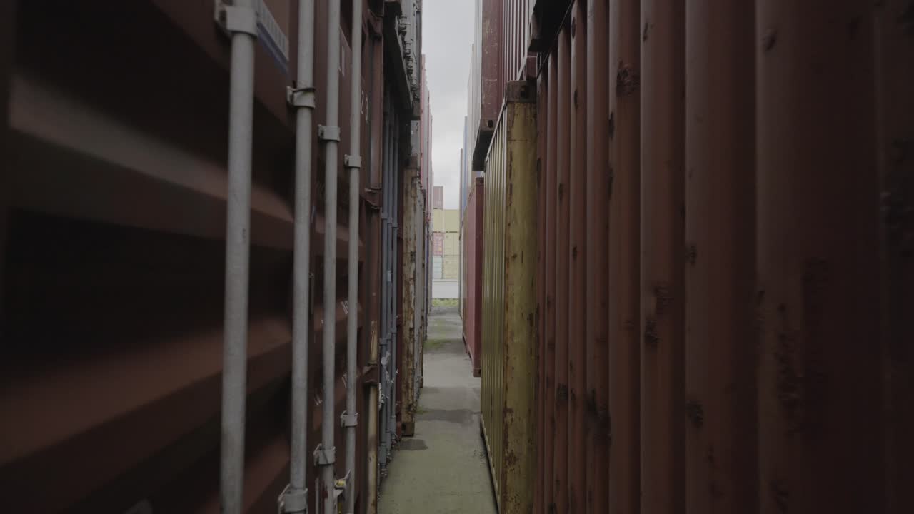 Camera walking through a confined cargo container alley with industrial textures