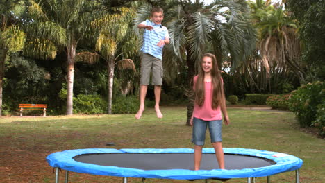 siblings jumping on a trampoline