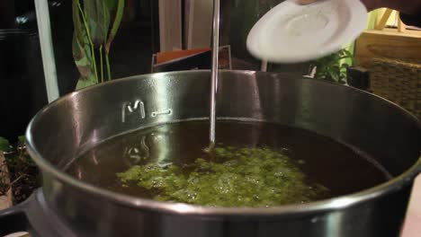 green hops being poured into a stainless steel pot