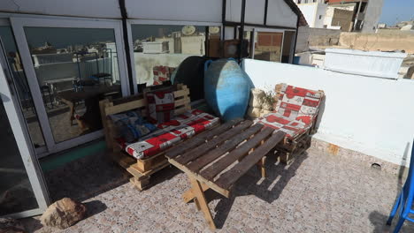 rustic rooftop patio with handmade wooden furniture and colorful cushions in an ancient arabic city