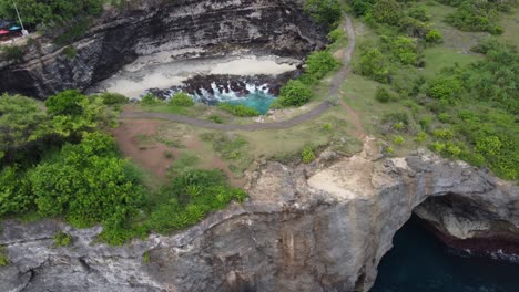 Toma-De-Revelación-Aérea-De-Playa-Rota-En-La-Isla-De-Nusa-Penida-Y-Su-Puente-De-Arco-Natural,-Bali