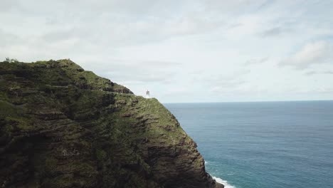 drone shot approaching the makapu'u lighthouse which is on a cliffside of oahu, hawaii