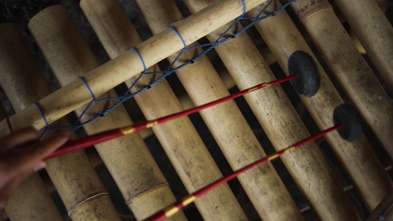 Slow Motion handheld shot of someone playing an Indonesian Xylophone