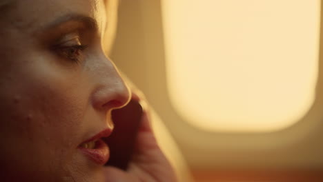 Beautiful-woman-chatting-phone-at-porthole-closeup.-Smiling-passenger-on-trip