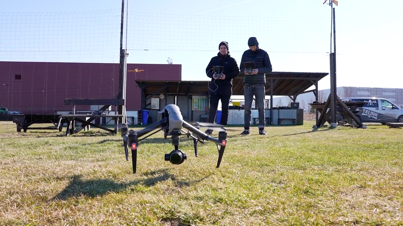 Roterende optagelse af to mænd, der styrer en stor Inspire DJI-drone