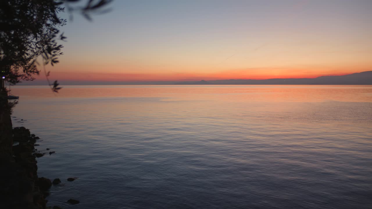 Pan right of magnificent golden sunset on Lake Garda, Italy.