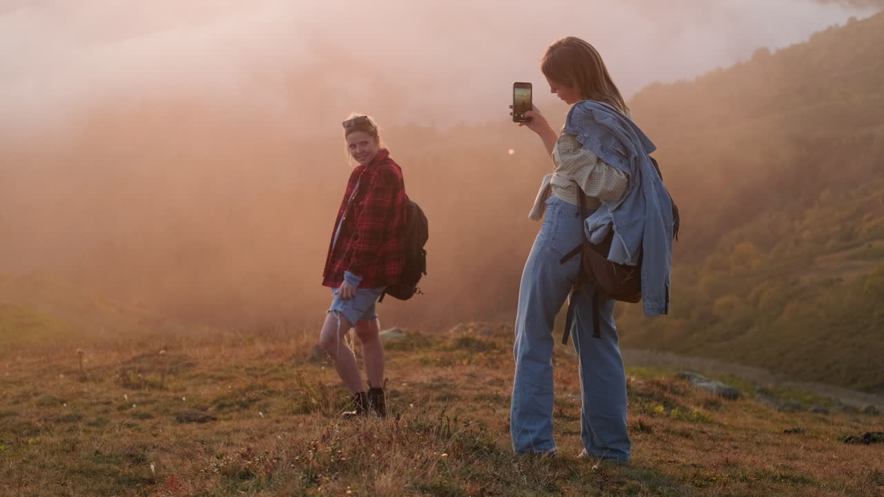 dos mujeres caminando por las montañas al atardecer