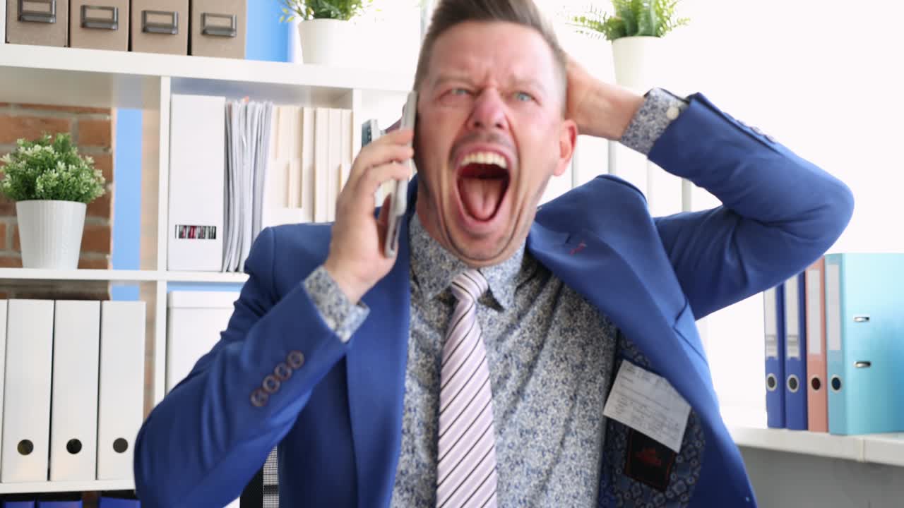 젊은 사업가가 직장에서 스마트폰으로 소리를 지르며 4k 영화