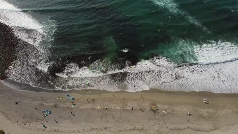 Surfistas-Disfrutando-Del-Agua-Turquesa---Olas-Espumosas-De-La-Playa-De-Unstad,-Lofoten,-Noruega