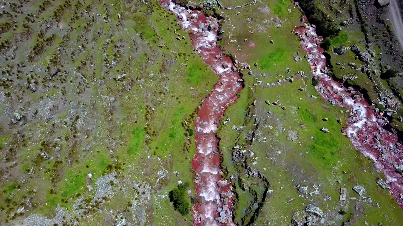 Aerial, drone shot overlooking the Pukamayu Red River, on a overcast day, in Cusco, Peru, South America