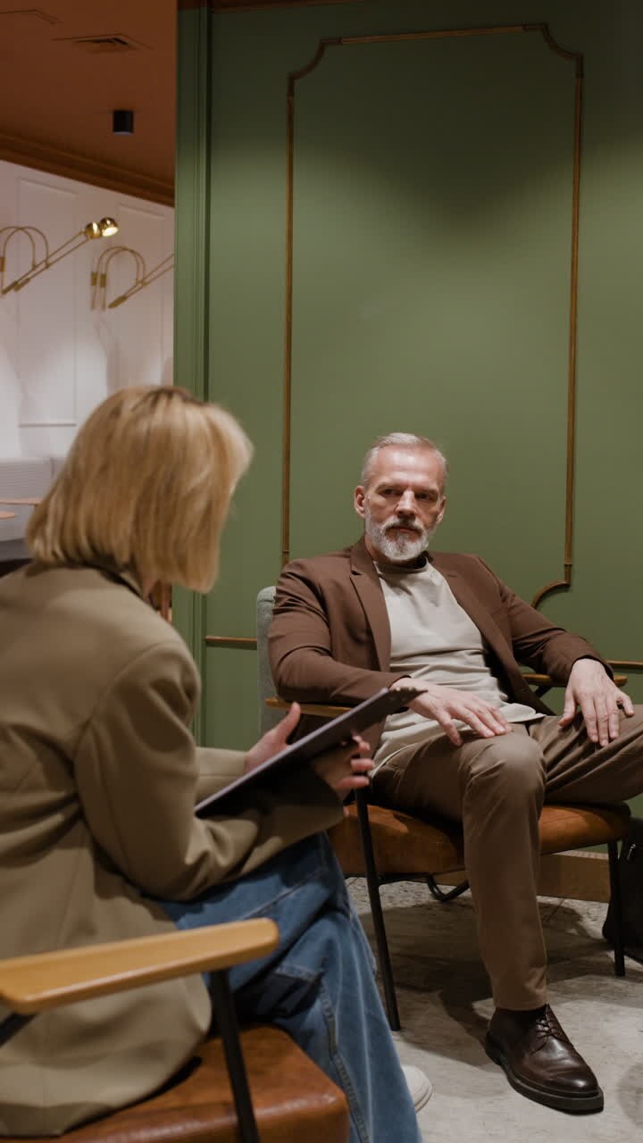 Two people engaged in a discussion or interview in a professional indoor setting
