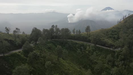vientos de carretera alrededor de la montaña a través del valle desde el volcán mt bromo, idn
