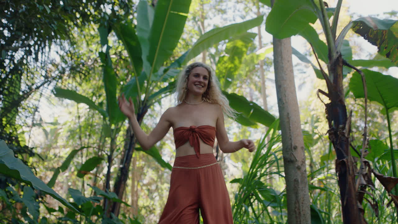 hermosa mujer bailando en el bosque disfrutando de la naturaleza bailando en la exuberante jungla tropical 4k