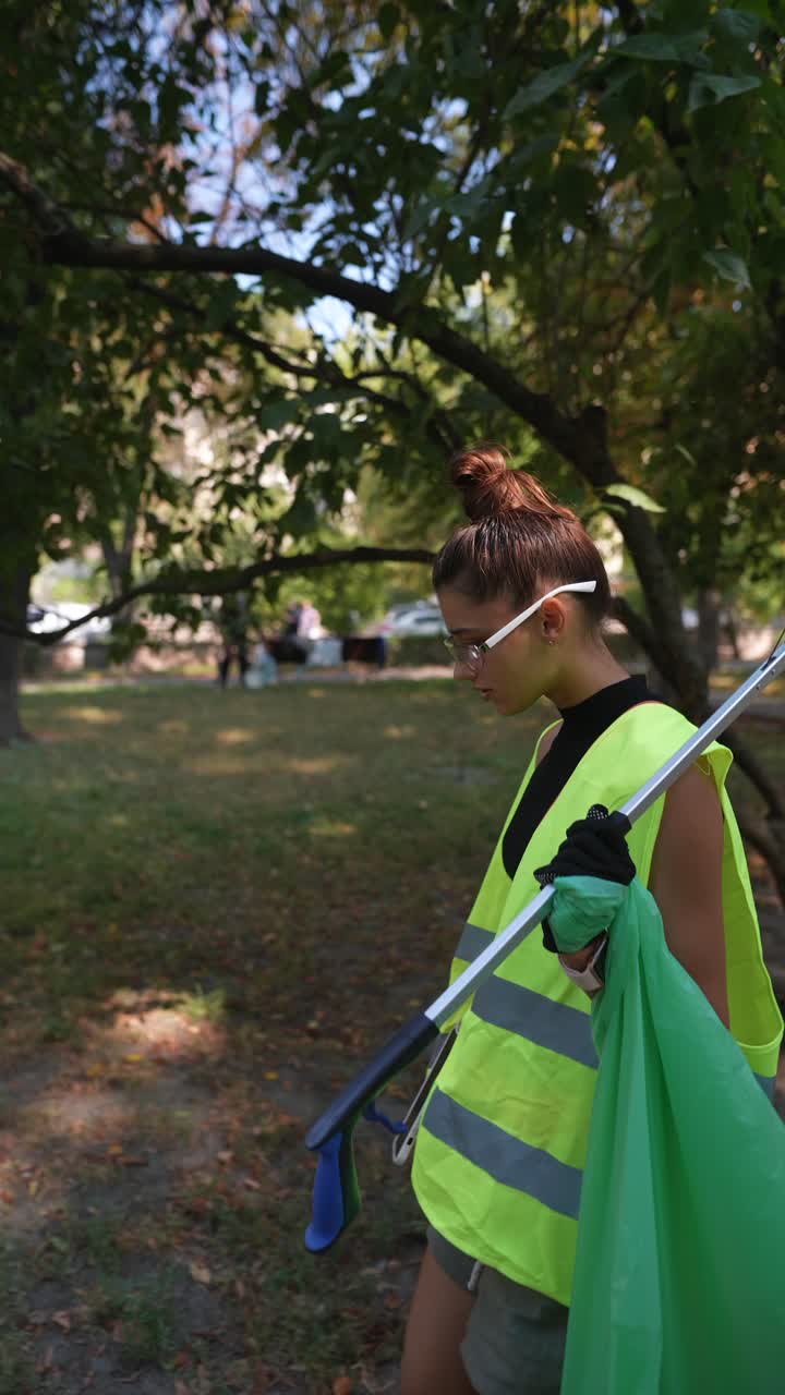 mujer limpiando la basura en un parque