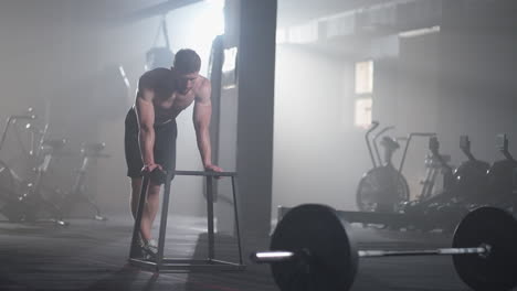 an athlete exhausted by training in the gym after performing the exercise rests and gains strength. a dense strong man recovers during a workout