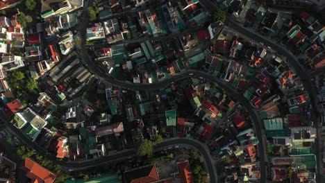 Dalat-City-or-Da-lat,-Vietnam-top-down-drone-shot-over-city-center-featuring-winding-roads-with-cars-and-motorbikes