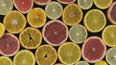 rotation, background from cut slices of citruses on a black background.