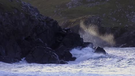 goldene stunde aufnahme der wellen, die gegen die klippen am dalmore beach in der nähe von carloway schlagen