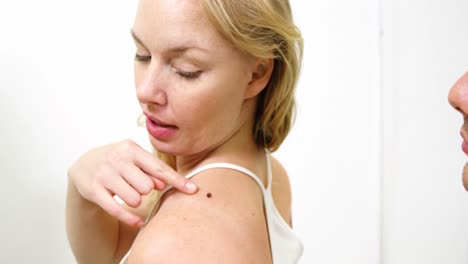 dermatólogo examinando el lunar con lupa
