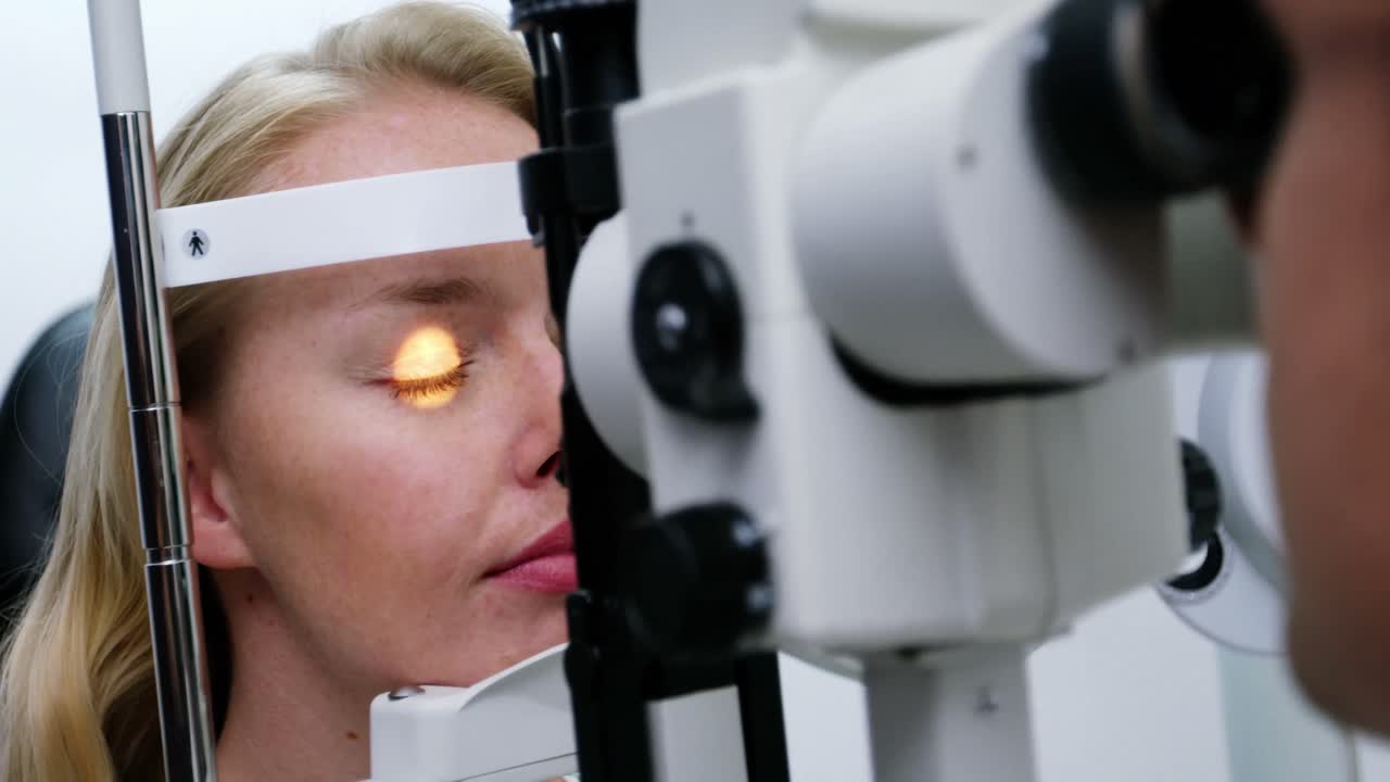 optometrista examinando a una paciente en una lámpara de hendidura