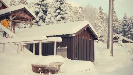 man shoveling snow around cabins in indre fosen, norway - static