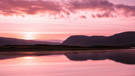 vibrant pink and purple sunset over a serene mountain lake