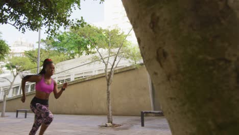 African-american-woman-exercising-outdoors-wearing-wireless-earphones-running-in-the-city