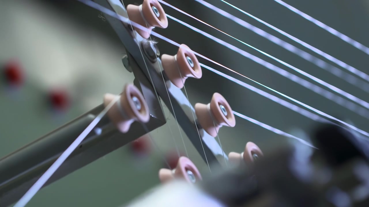 Industrial modern automation factory production line weaving plant of polypropylene yarn spools bags. White reels with ropes making plastic sacks in a modern nylon manufacture enterprise, close up