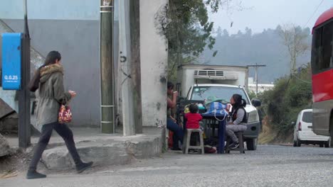 slow motion street view woman walking, family with kids at table, vehicles passing zone 18 guatemala city