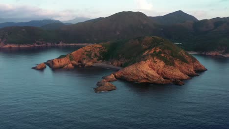 aerial drone view of small island and coastline at sai kung national park surrounded by mountains. geographical lanscape and rugged coastline of island in hong kong.