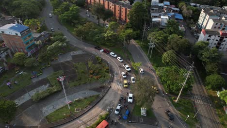 drone shot of a busy roundabout and overpass in a vibrant city, capturing flowing traffic patterns and urban infrastructure.