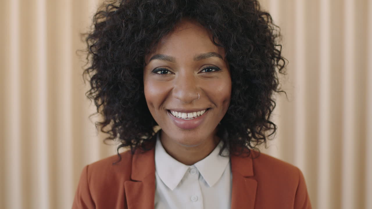 retrato de cerca de una joven afroamericana elegante con peinado afro riendo feliz mirando a la cámara mujer negra de moda con traje
