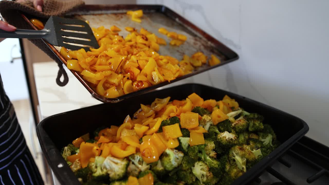 Pouring Roasted Squash On Chopped Broccoli In Pan. - closeup shot