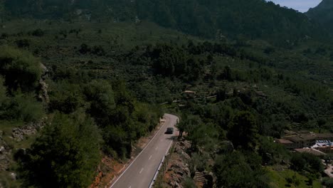 Modern-car-driving-along-a-road-at-Port-de-Soller-Fornalutx-mountain-village,-Puig-Major,-Palma-de-Mallorca
