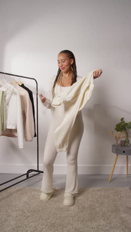 vídeo vertical de pov de una influyente femenina de las redes sociales produciendo contenido generado por el usuario en el estudio modelando una variedad de trajes de moda filmados en tiempo real 2