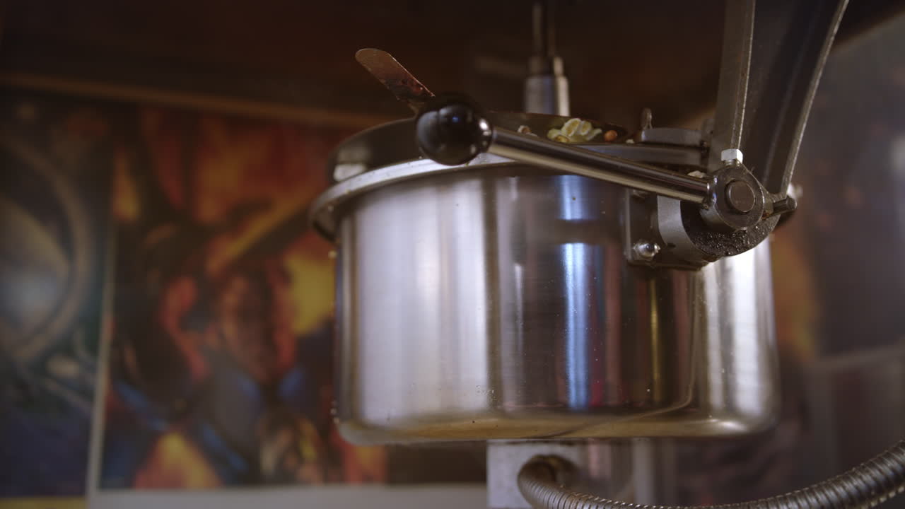 Popcorn pour out of popcorn machine. Worker control popcorn production process