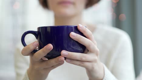 woman holding a blue coffee cup