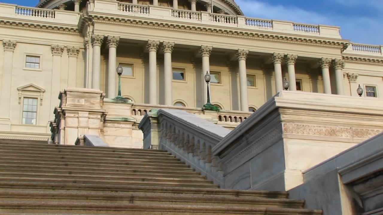 카메라가 워싱턴 dc에 있는 미 국회의사당 건물 계단에서 랜드마크 돔과 맨 위에 있는 주철 자유 동상까지 패닝합니다.