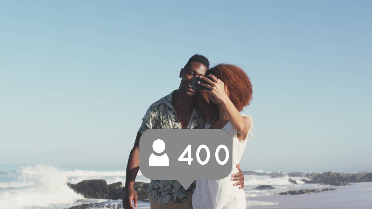 iconos de perfil con números crecientes contra una pareja afroamericana tomando una selfie en la playa