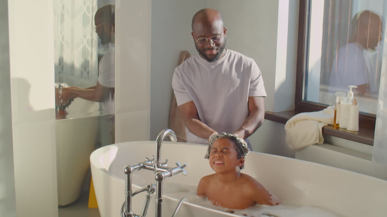 African American Dad Bathing Little Son at Home