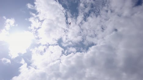 an extreme wide of an air trike flying through the clouds from below on a fine day